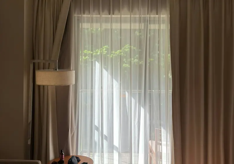 Habitación luminosa con cortinas y sillón