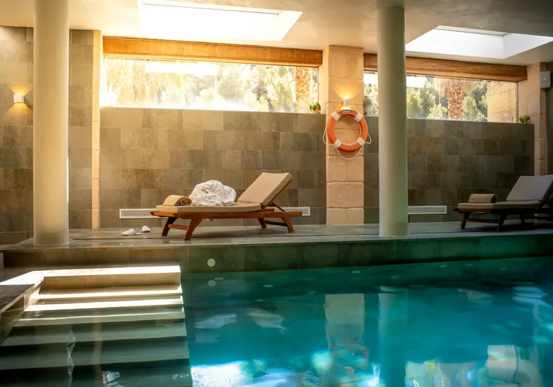 Piscina interior de un spa con tumbonas
