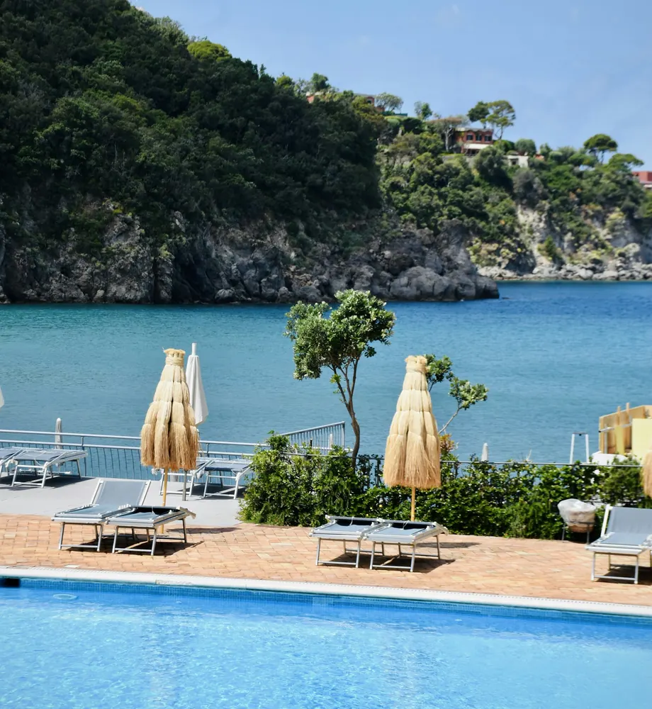 Piscina con hamacas y vistas al mar y a la montaña